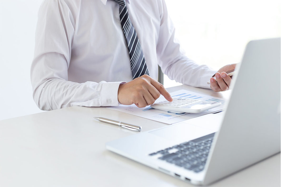 Office work. Businessman work on computer with finances. Blurred background, film effect.